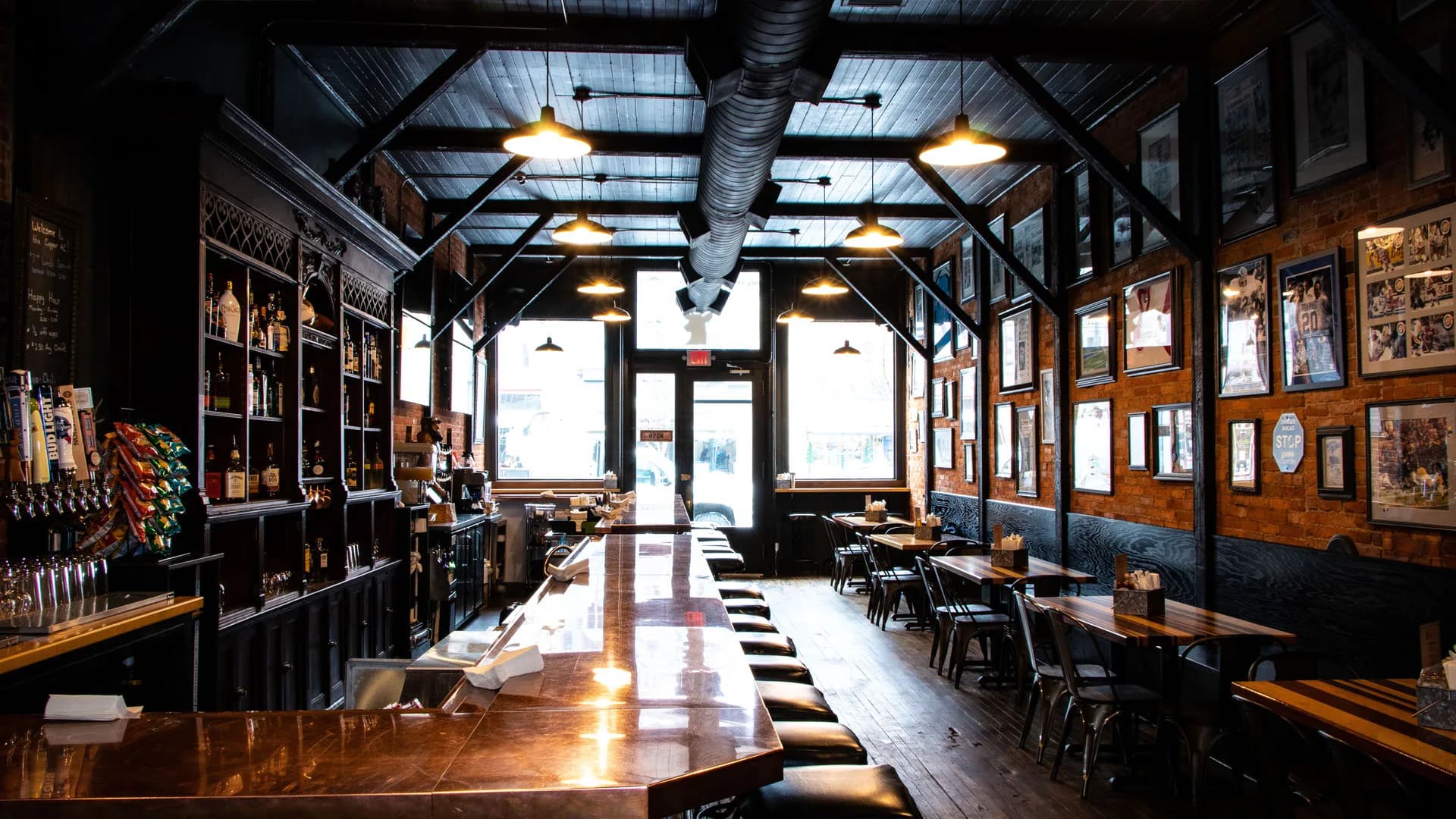 The Copper Athletic Club dining room, with the long copper bar, exposed beams and walls of framed Detroit sports memorabilia